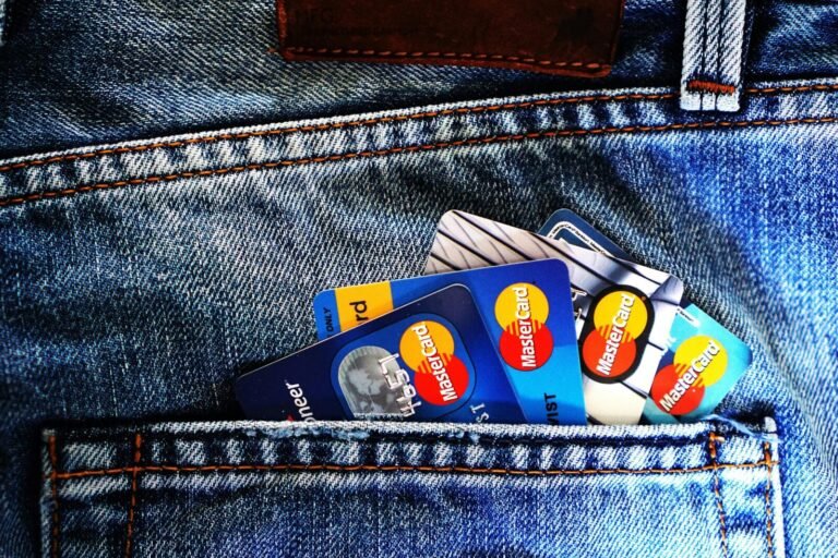 Close-up of a denim pocket with multiple credit cards, illustrating finance and fashion.