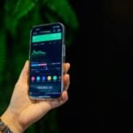 Close-up of a smartphone displaying a stock trading app with market data on-screen.